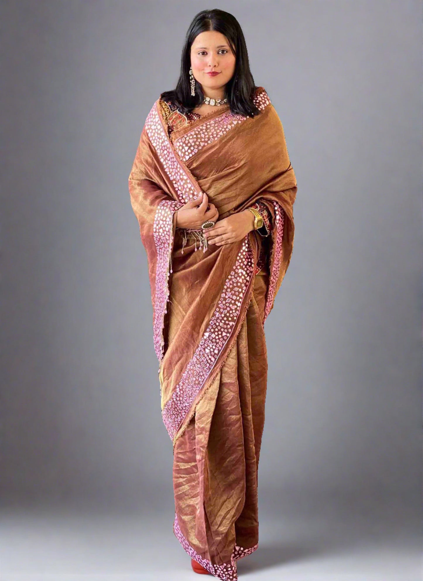 A woman wearing Brown Mirror Work Saree