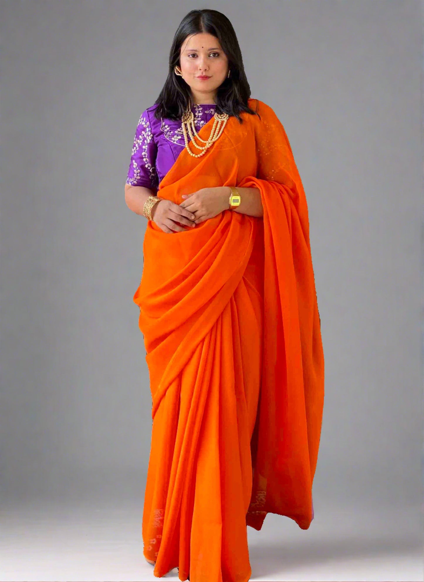 A woman wearing Orange Georgette Saree