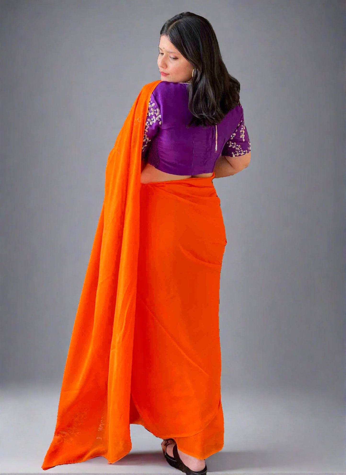 A woman wearing Orange Georgette Saree
