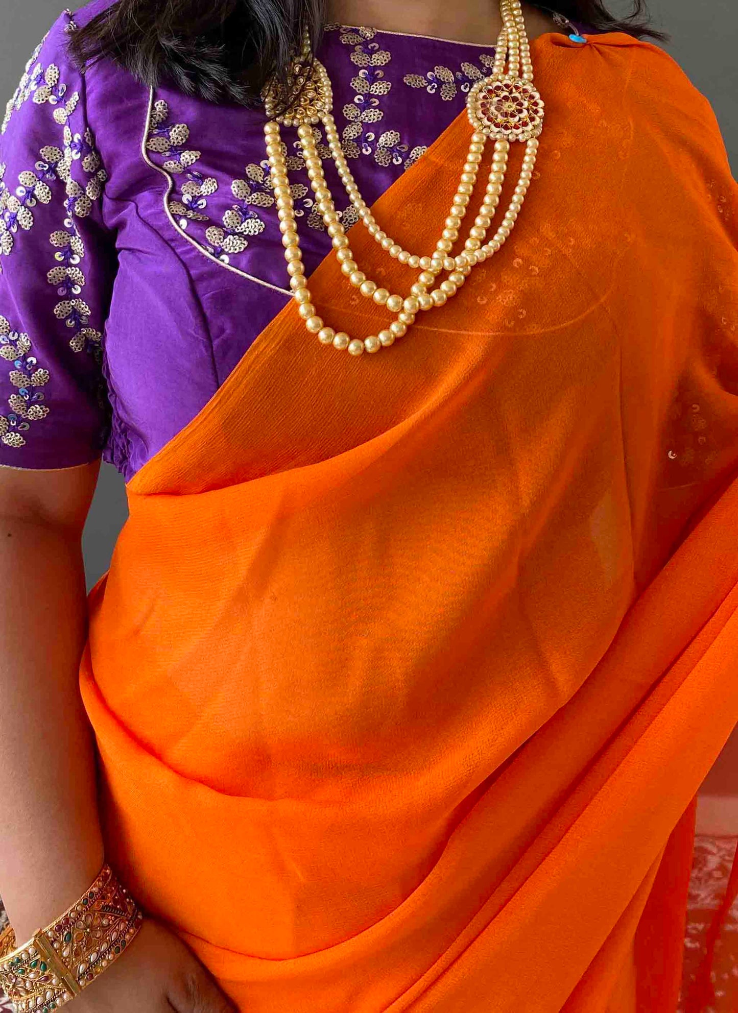 A woman wearing Orange Georgette Saree